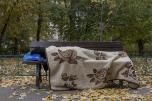 A woman sleeps on a bench near Gara de Nord in Bucharest, Romania on November 6, 2011. During the winter hundreds of persons, sleep in the basement of the city to find heat. 