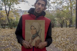 A drug addict man shows the reproduction of a Nicolae Grigorescu painting near Gara de Nord in Bucharest, Romania on November 6, 2011. During the winter hundreds of persons, sleep in the basement of the city to find heat. 