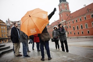 A tourist guide give explanations to a group of visitors at Plac Zamkowy in the historic center of Warsaw on February 13, 2014.