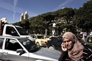 A woman talking on the phone while walking through the traffic of Avenue Bourguiba in Tunis on October 18, 2012.