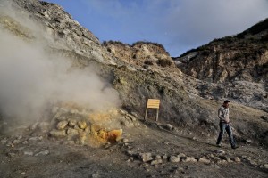 A man walks near fumaroles emerging from the Solfatara crater in Pozzuoli, Italy, on April 12, 2014. Fumaroles are volcanic steam releases that contain sulfur causing a malodour similar to addle eggs.  