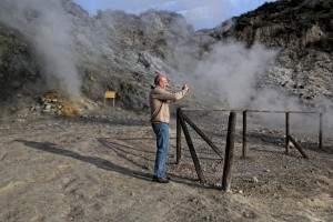 A man take a picture of fumaroles emerging from the Solfatara crater in Pozzuoli, Italy on April 12, 2014. Fumaroles are volcanic steam releases that contain sulfur causing a malodour similar to addle eggs. 