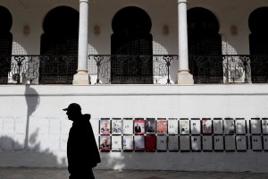 A man walks near election posters attached on the wall of tunisian ministry of finance in Tunis on November 13, 2014.