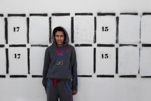 A boy is portrayed near a wall intended to accommodate election posters in Tunis on November 19, 2014.