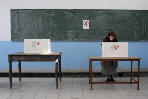 A Tunisian woman prepares to casts her vote in the country’s first post-revolution presidential election in a school of Tunis turned in a polling station on November 23, 2014. 