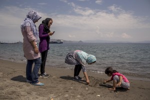 A migrant family from Syria play on a beach near the port in Kos island, Greece on June 8, 2015. Hundreds of migrants are continuing to arrive on the Greek Island from Turkey. The island has recently seen a drop in tourist numbers which has been attributed to negative reports on the migrant crisis that is continuing to grip the area. Around 30,000 migrants have entered the country so far this year, with the government calling for more help from its European Union counterparts.
