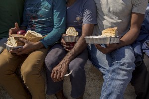 Migrants from Afghanistan, Pakistan and Syria are seen after getting food aid outside an abandoned hotel where many migrants sleep in Kos island, Greece on June 10, 2015. Many migrants are continuing to arrive on the Greek Island of Kos from Turkey. The Island has recently seen a drop in tourist numbers which has been attributed to negative reports on the migrant crisis that is continuing to grip the area. Around 30,000 migrants have entered Greece so far in 2015, with the country calling for more help from its European Union counterparts.