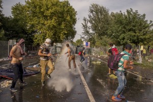 Hungarian riot police using a water cannon against protesting migrants on the Serbian side of the border in Horgos, Serbia on September 16, 2015. Hungary’s border with Serbia has become a major crossing point into the European Union, with more than 160,000 access Hungary so far this year.