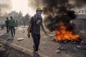 Migrants throw rocks and try to remove the gates during clashes with Hungarian anti-riot police at the Serbian border with Hungary in Horgos, Serbia on September 16, 2015. Hungary’s border with Serbia has become a major crossing point into the European Union, with more than 160,000 access Hungary so far this year.