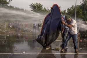 Hungarian riot police using a water cannon against protesting migrants on the Serbian side of the border in Horgos, Serbia on September 16, 2015. Hungary’s border with Serbia has become a major crossing point into the European Union, with more than 160,000 access Hungary so far this year.