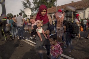 A woman flees with her children after Hungarian riot police using tear gases against protesting migrants on the Serbian side of the border, near Horgos in Serbia on September 16, 2015. Hungary’s border with Serbia has become a major crossing point into the European Union, with more than 160,000 access Hungary so far this year.