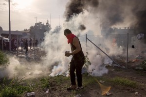 Migrants throw rocks and try to remove the gates during clashes with Hungarian anti-riot police at the Serbian border with Hungary in Horgos, Serbia on September 16, 2015. Hungary’s border with Serbia has become a major crossing point into the European Union, with more than 160,000 access Hungary so far this year.