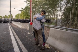 A man holds a syrian girl in front of the the Hungarian anti-riot police at the Serbian border with Hungary in Horgos, Serbia on September 16, 2015. Hungary’s border with Serbia has become a major crossing point into the European Union, with more than 160,000 access Hungary so far this year.