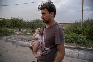 A man with his son near Tovarnik train station where migrants leave to Zagreb despite moves by Slovenia and Hungary to hold them back in Tovarnik, Croatia on September 19, 2015.