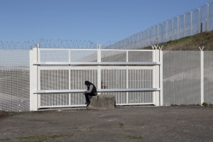 January 28, 2016 – Calais, France: A migrant is seen outside the refugee camp of Calais, known as “The Jungle”, where hundreds of meters of barriers have been erected to prevent migrants to access the highway and hide on trucks headed to England. While migrants have for years sought to cross over to Britain from Calais, the numbers have shot up since the refugee crisis went into overdrive last year.