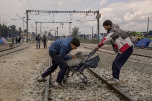 Migrants carry a stroller containing firewood at the Idomeni refugee camp in Idomeni, Greece on March 17, 2016. Refugees’ “journey of hope” towards Western European countries where they dream of having a better life ends in the Balkans following the latest agreement between EU and Turkey.