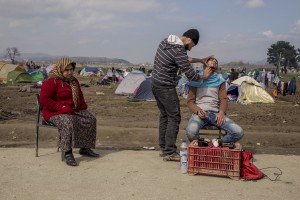 A man get a shave beard at the makeshift camp at the Greek-Macedonian border near the village of Idomeni in Greece on March 20, 2016.