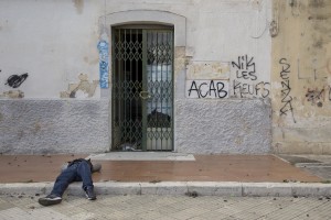 LECCE, ITALY – NOVEMBER 13: A migrant rests on the ground outside the train station of Lecce where a lot of migrants sleep during the night, because of the lack of facilities that could accommodate them in Puglia, Southern Italy on November 13, 2016.