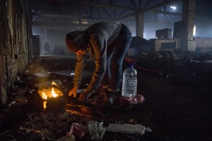 A migrant warms up around a fire in an abandoned warehouse in Belgrade, Serbia on February 4, 2017. Hundreds of migrants have been sleeping in freezing conditions in downtown Belgrade looking for ways to cross the heavily guarded EU borders.