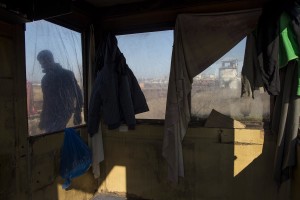 A migrant is seen through the window of a cabin built outside an abandoned warehouse where he and other migrants took refuge in Belgrade, Serbia on February 5, 2017. Hundreds of migrants have been sleeping in freezing conditions in central Belgrade looking for ways to cross the heavily guarded EU borders.