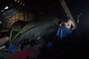 A migrant wearing a shirt in an abandoned warehouse in Belgrade, Serbia on February 3, 2017. Hundreds of migrants have been sleeping in freezing conditions in downtown Belgrade looking for ways to cross the heavily guarded EU borders.