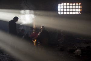 Migrants rest around a fire to warm theirselves from the cold in an abandoned warehouse in Belgrade, Serbia on February 4, 2017. Hundreds of migrants have been sleeping in freezing conditions in downtown Belgrade looking for ways to cross the heavily guarded EU borders.