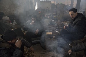 Migrants sit drinking a tea inside an abandoned warehouse where they took refuge in Belgrade, Serbia on February 4, 2017. Hundreds of migrants have been sleeping in freezing conditions in central Belgrade looking for ways to cross the heavily guarded EU borders.