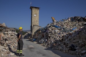 A firefighter walks among the rubble inside the red zone almost one year after the earthquake in the village of Amatrice, central Italy on August 1, 2017. Italy was struck by a powerful 6.2 magnitude earthquake in the night of August 24, 2016 which has killed at least 297 people and devastated dozens of houses in the Lazio village of Amatrice and other Amatrice fractions.