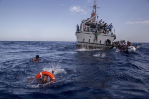 Some migrants swim towards the rescue boats of the German NGO Sea-Watch after having escaped from the Libyan Coast Guard ship in the Mediterranean Sea on November 6, 2017. During a shipwreck, five people died, including a newborn child. According to the German NGO Sea-Watch, which has saved 58 migrants, the violent behavior of the Libyan coast guard caused the death of five persons.