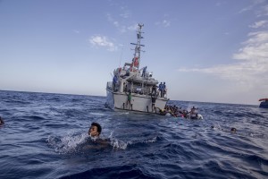 Some migrants swim towards the rescue boats of the German NGO Sea-Watch after having escaped from the Libyan Coast Guard ship in the Mediterranean Sea on November 6, 2017. During a shipwreck, five people died, including a newborn child. According to the German NGO Sea-Watch, which has saved 58 migrants, the violent behavior of the Libyan coast guard caused the death of five persons.