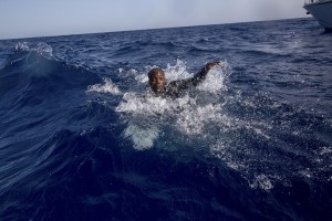 A migrant tries to board a boat of the German NGO Sea-Watch in the Mediterranean Sea on November 6, 2017. During a shipwreck, five people died, including a newborn child. According to the German NGO Sea-Watch, which has saved 58 migrants, the violent behavior of the Libyan coast guard caused the death of five persons.
