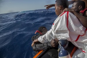 A migrant tries to board a boat of the German NGO Sea-Watch in the Mediterranean Sea on November 6, 2017. During a shipwreck, five people died, including a newborn child. According to the German NGO Sea-Watch, which has saved 58 migrants, the violent behavior of the Libyan coast guard caused the death of five persons.