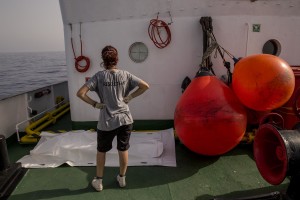 A doctor of the Spanish NGO Proactiva Open Arms looks the white bag containing the body of a child found dead about 85 miles off the Libyan coast in the Mediterranean sea on July 17, 2018.