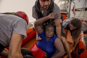 Members of the Spanish NGO Proactiva Open Arms rescue boat carry Josepha, an African migrant from Cameroon, in the Mediterranean sea on July 17, 2018.