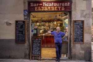 A man outside his bar in the Raval district in Barcelona, Spain on July 12, 2018. The Raval is one of the most multicultural and colorful neighborhoods in the city and it hosts numerous artists and galleries.