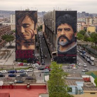 Two murals depicting the Argentine football player Diego Armando Maradona and a child realized by the Italian street artist “Jorit” are seen on the facades of two buildings in San Giovanni a Teduccio, near Naples, in Italy on May 9, 2019.