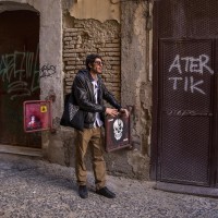 A tour guide shows a graffiti of the French street artist “C215” in the alleys of the Neapolitan historical center, during a street art tour organized by the cultural association “400 ml” in Naples, Italy on March 24, 2019. Napoli Paint Stories streetart and graffiti tour is a touristic walk in the neapolitan historical center through murales, stencils, slogans, posters and graffiti to discover urban art.