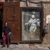 A woman is seen near the moural known as “Madonna with the gun” of the English street artist Banksy in Naples, Italy on March 24, 2019. “Madonna with the gun” is the only work in Italy realized by Banksy.