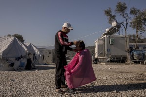 An Afghan man gets his hair cut inside the Moria refugee camp on the island of Lesbos in Greece on February 18, 2020. About 20000 migrants and asylum seekers – mostly coming from Afghanistan and Syria – live in the official Moria camp and in the olive grove that is located nearby.