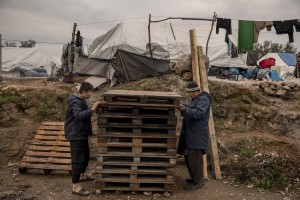 People collect wood to build a tent inside the Moria refugee camp on the island of Lesbos in Greece on February 20, 2020. About 20000 migrants and asylum seekers – mostly coming from Afghanistan and Syria – live in the official Moria camp and in the olive grove that is located nearby.