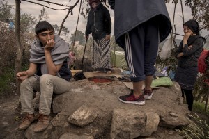 People are seen around a furnace inside the Moria refugee camp on the island of Lesbos in Greece on February 20, 2020. About 20000 migrants and asylum seekers – mostly coming from Afghanistan and Syria – live in the official Moria camp and in the olive grove that is located nearby.