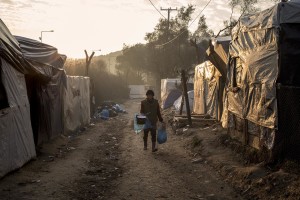 A woman walks inside the Moria refugee camp on the island of Lesbos in Greece on February 19, 2020. About 20000 migrants and asylum seekers – mostly coming from Afghanistan and Syria – live in the official Moria camp and in the olive grove that is located nearby.