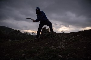 A man chops wood from a tree to prepare the nght fire inside the Moria refugee camp on the island of Lesbos in Greece on February 21, 2020. About 20000 migrants and asylum seekers – mostly coming from Afghanistan and Syria – live in the official Moria camp and in the olive grove that is located nearby.