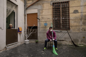 A woman and a man rest after disinfecting the courtyard of a building on the eighth day of unprecedented lockdown across of all Italy imposed to slow the spread of coronavirus in Naples, Southern Italy on March 17, 2020.