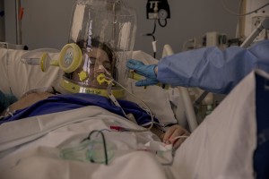 A nurse takes care of a patient who lie in bed inside the coronavirus intensive care unit of the “Papa Giovanni XXIII” hospital in Bergamo, Northern Italy on April 17, 2020.