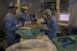 Nurses take care of a patient who lie in bed inside the coronavirus intensive care unit of the “Papa Giovanni XXIII” hospital in Bergamo, Northern Italy on April 17, 2020.