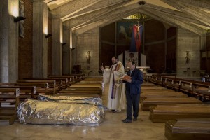 Father Marcello (left) and Father Mario Carminati (right) bless the coffins of coronavirus victims inside San Giuseppe church in Seriate, province of Bergamo, Northern Italy on April 15, 2020.