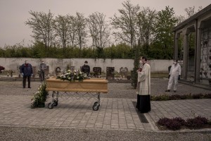 A priest blesses the coffin of a 47 years old man died of coronavirus, inside the cemetery of Locate Bergamasco, province of Bergamo, Northern Italy on April 16, 2020.