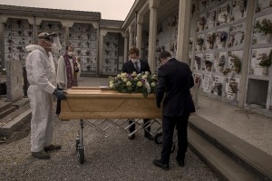 Funeral agency employees introduce the coffin of a 47 years old man died of coronavirus, inside a tomb in the cemetery of Locate Bergamasco, province of Bergamo, Northern Italy on April 16, 2020.