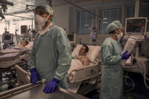 Nurses take care of their patients who lie in bed inside the coronavirus intensive care unit of the “Poliambulanza Foundation” hospital in Brescia, Italy on April 9, 2020. “Poliambulanza Foundation” is a non-profit multispecialist private hospital, affiliated with the National Health Service.